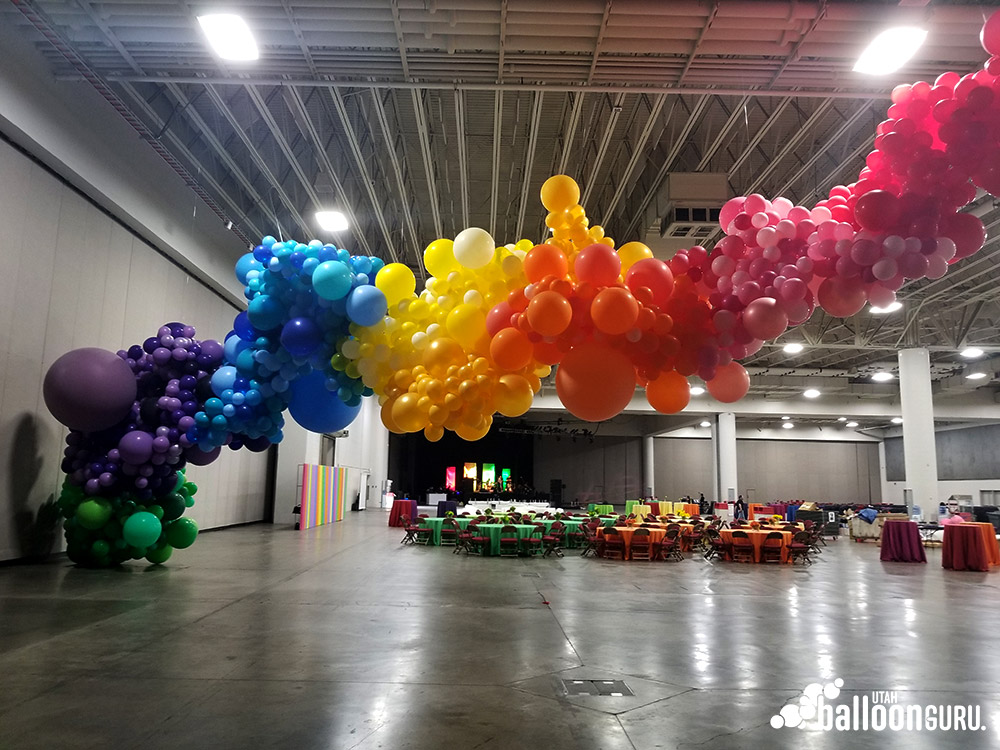 Colorful rainbow balloon arch decorating a walkway.